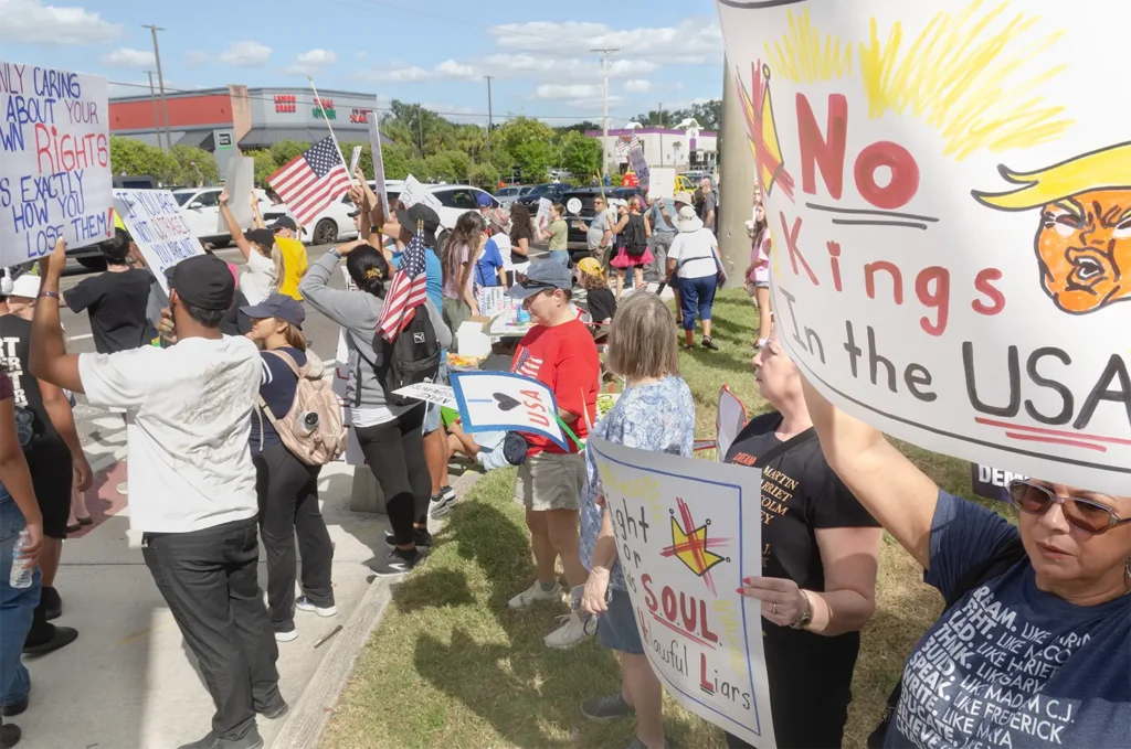 Rally goers and No Kings sign