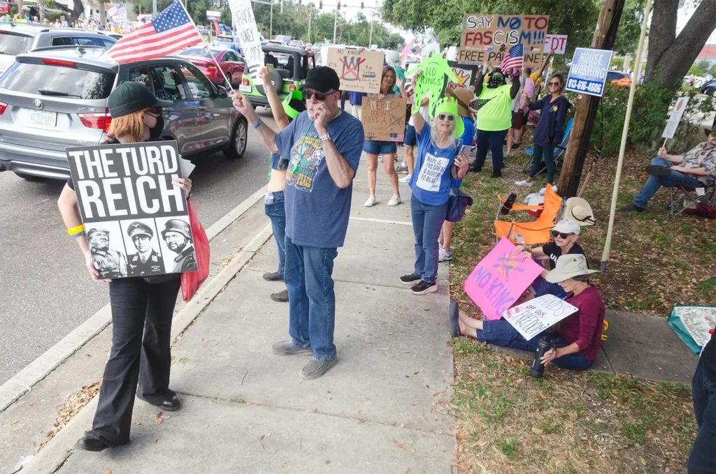 Rally goers and The Turd Reich sign
