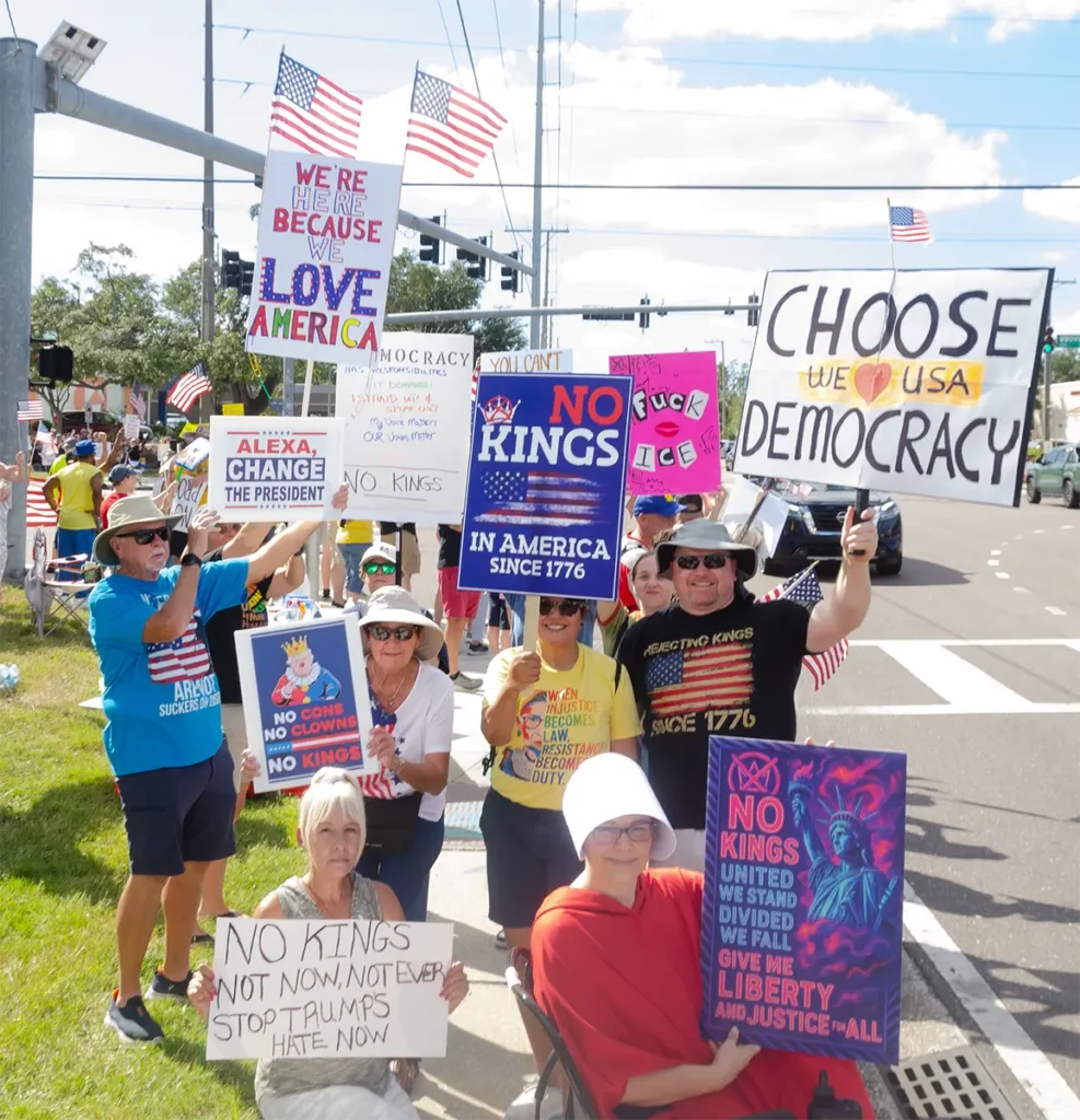 Rally goers and No Kings signs