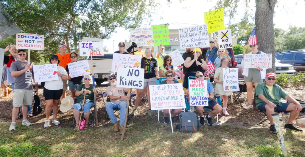 Rally goers and No Kings signs