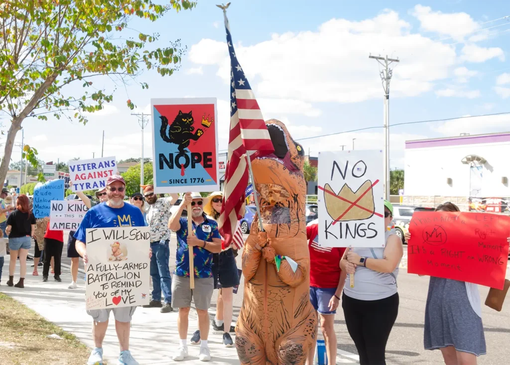 Rally goers and No Kings sign