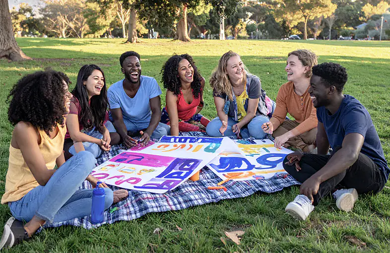 People having outrageously too much fun making political signs in a park.